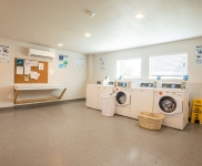 laundry rooms with four washers and folder counter