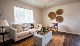 living room with couch, window, ottoman, armchair, and side table with lamp