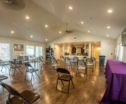 Community Learning Center room with folding chairs spaced apart and two tables with tablecloths
