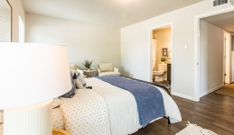 master bedroom with bed, nightstand lamp, arm chair