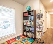 Community Learning Center book nook with bookcase, book turnstile, books, rug, and globe