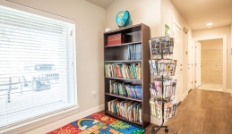 Community Learning Center book nook with bookcase, book turnstile, books, rug, and globe