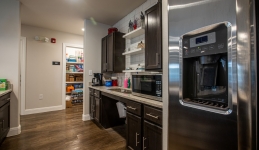 Community Learning Center kitchen with refrigerator, counter, sink, microwave, and cabinets