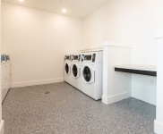 three washing machines and folding counter in laundry room